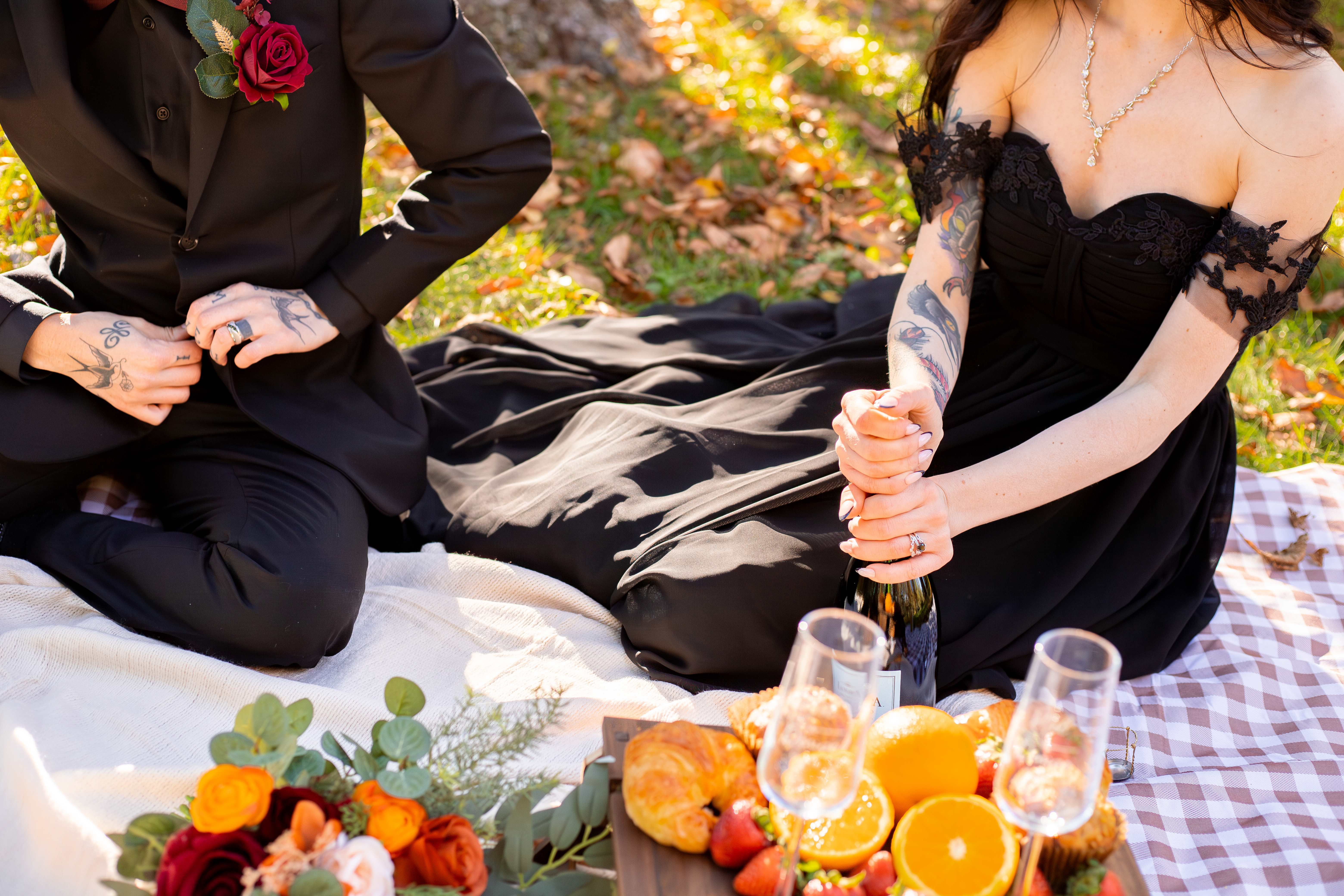Close detail of elopement picnic with florals, champagne, croissants and fruit on a styled blanket in Shenandoah National Park